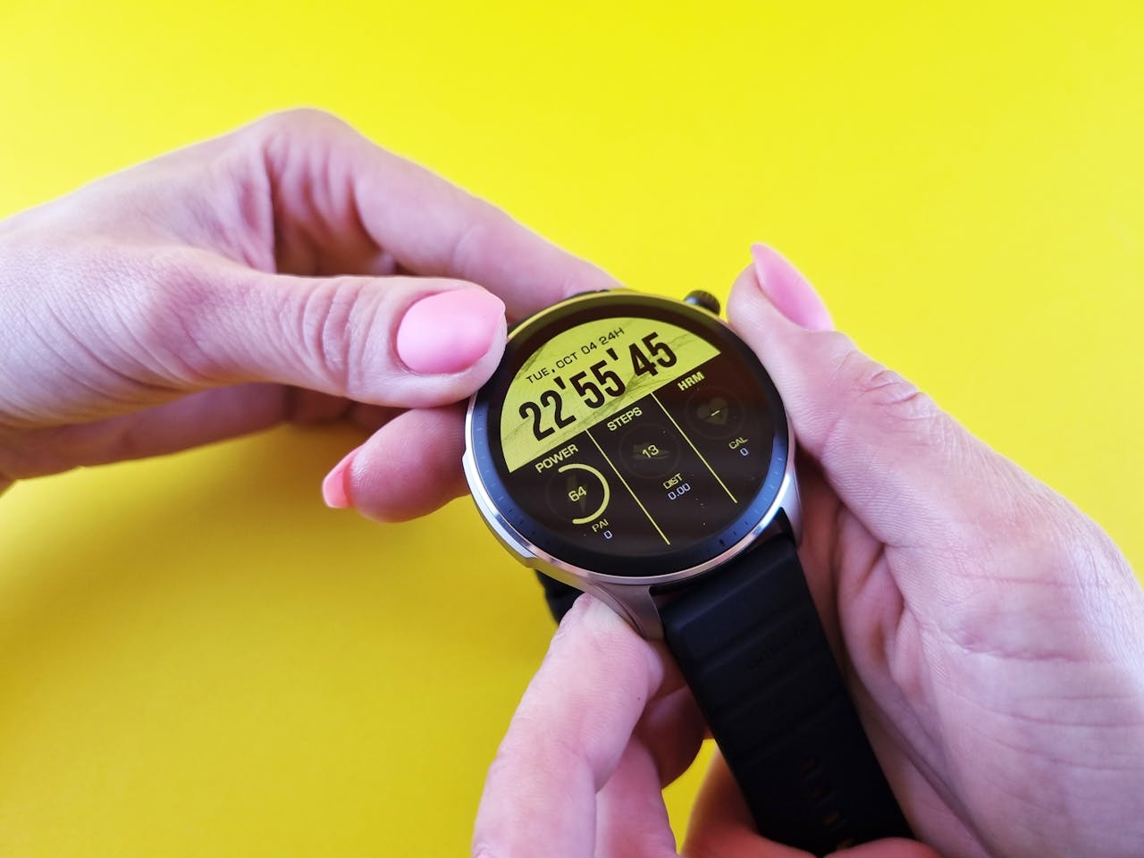 services-02 Close-up of hands holding a sleek smartwatch, highlighting technology against a bright yellow background.