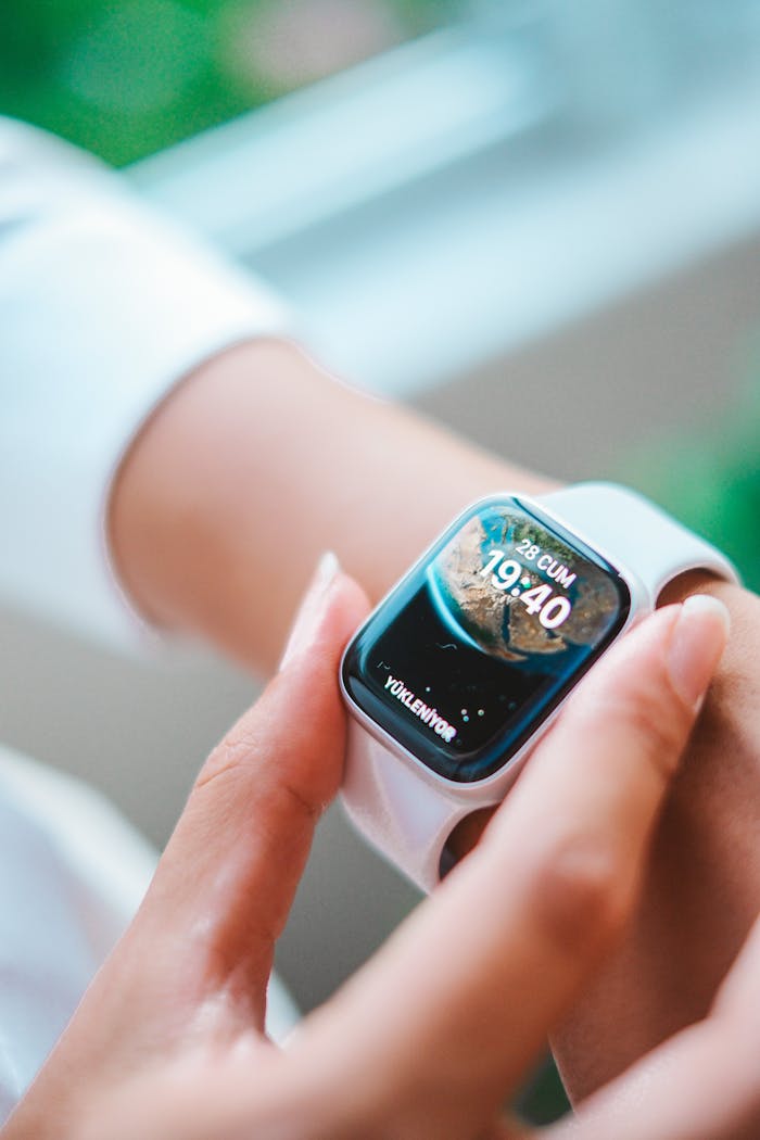 services-01 Close-up of a person's hand adjusting a smartwatch indoors. Technology focus.