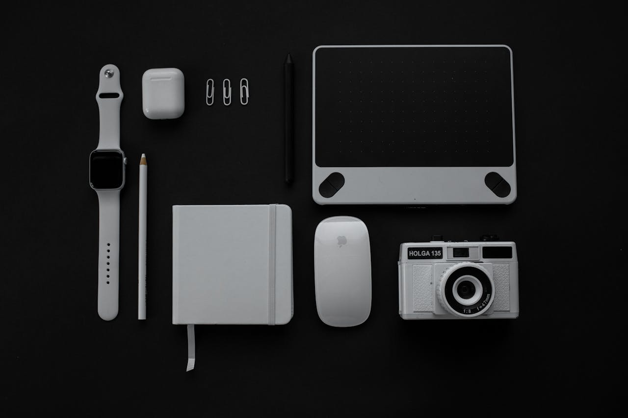 services-03 Flat lay of modern gadgets and accessories against a black background.